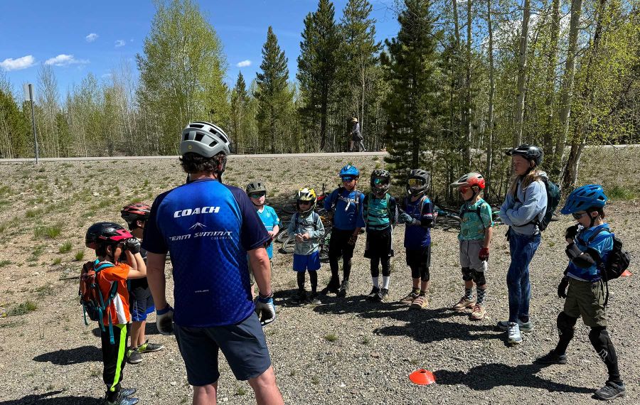 intro to mountain bike camp with riders listening to a coach before beginning 